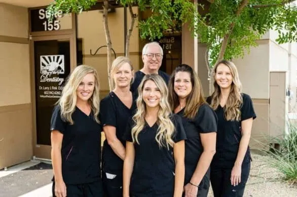 Dr Fink and five of his dental office staff stand in front of the Valley of the Sun Dentistry Office